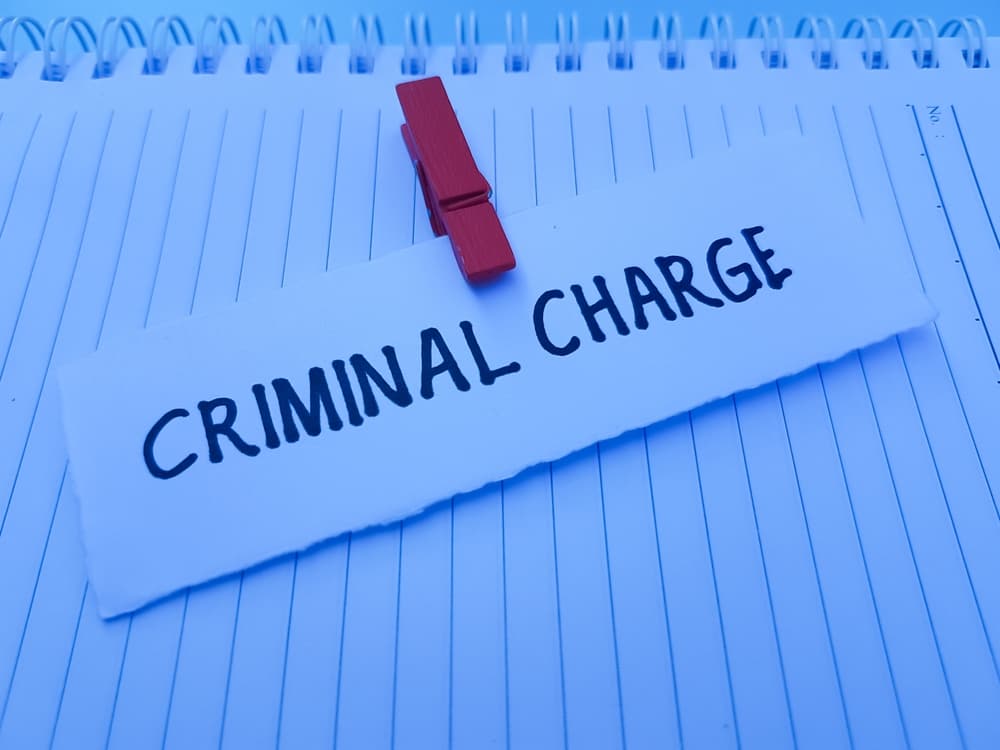 Criminal charge writting on paper background