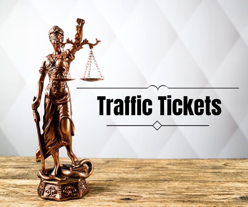 A neatly arranged composition focused on traffic law, featuring traffic tickets, various traffic signs, and legal documents spread across a clean surface. A gavel and a pen are included, symbolizing legal representation and decision-making. The elements are well-lit, creating a professional and informative aesthetic suitable for content related to traffic violations, ticket disputes, or legal advice.