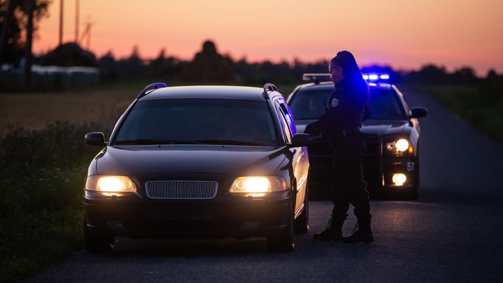 Highway Traffic Patrol Car Pulls over Vehicle on the Road. Female Police Officer Approaches Driver Asks for License and Registration. 