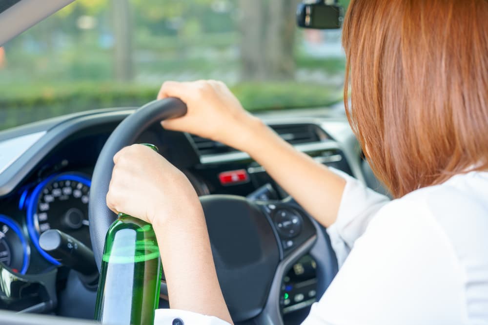 Teen Girl drinking beer and driving a car